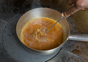 A hand whisk, whisking a pan of boiling hot chicken gravy made from the stock of a fresh organic...