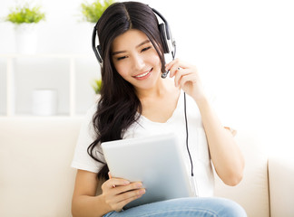young Woman with headphones and tablet in  living room