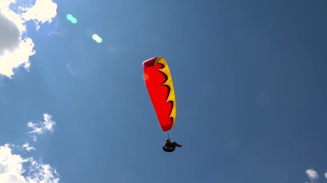 Flying Paraglider on a Background of the Sun and Beautiful Clouds