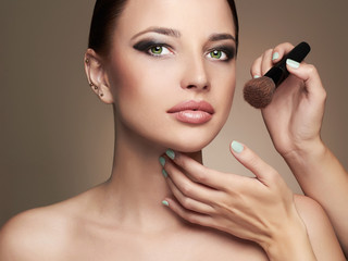Beautiful woman face. Skincare foundation.Make-up artist applies skin tone.model girl
