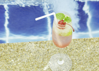 Mojito cocktail  on a swimming pool, cherry
