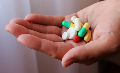 young woman holding pills in hand
