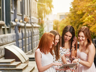 four girls friends toursits looking into tablet pc