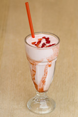 Milk drink with strawberry in a glass on white background