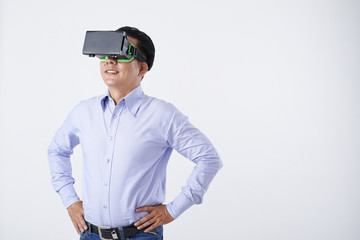 Portrait of smiling Vietnamese businessman in VR glasses