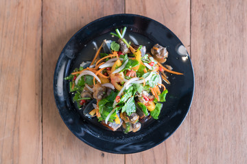 spicy cockle salad on wooden background