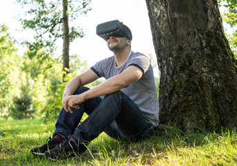 Man wearing virtual reality headset in park