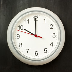 Photo of typical white office clock on dark background