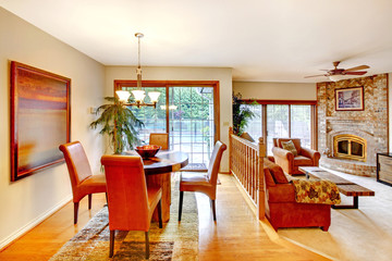 House with open floor plan. View of dining area with table set and brick fireplace in the living room.