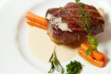 Grilled steak with carrots, close up isolated on white