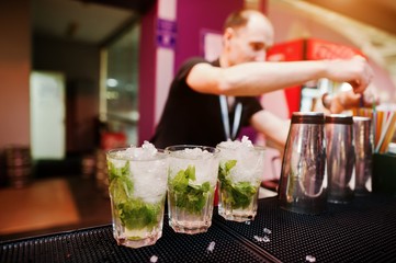 Bartender preparing mojito cocktail drink at the bar