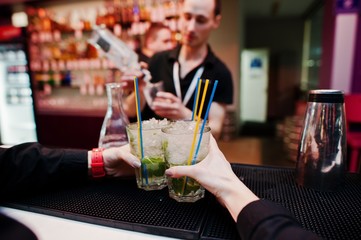 Bartender preparing mojito cocktail drink at the bar