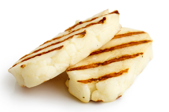 Two grilled slices of halloumi cheese isolated on white in perspective. With grill marks.