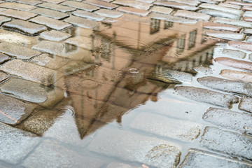 Cobblestone street with puddle on rainy day