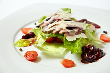 Salad with bacon, parmesan and cherry sauce, close up isolated on white