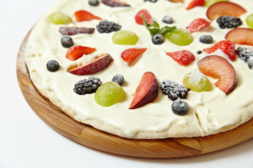 Sweet pizza with fruits and berries on white background