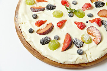 Sweet pizza with fruits and berries on white background