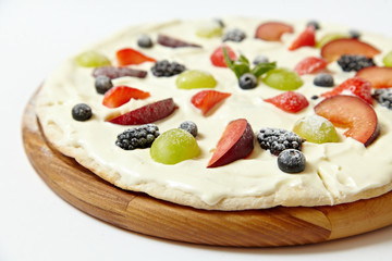 Sweet pizza with fruits and berries on white background