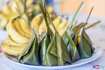Steamed Flour with Coconut Filling wrapped in banana leaf Thai T