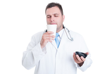 Male doctor or medic smelling fresh coffee from takeaway cup