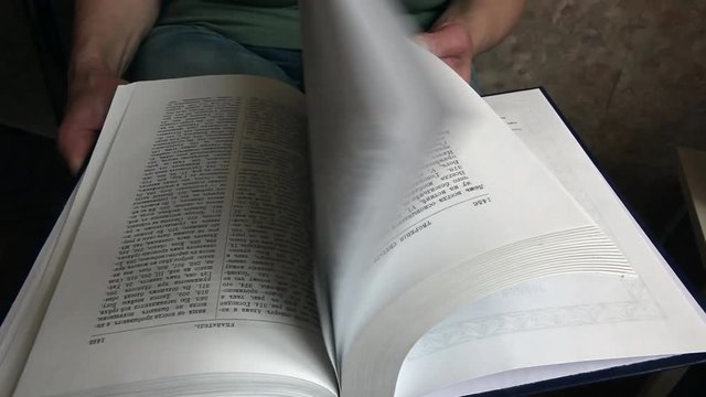 book, close-up of a great book, a book pages quickly turned over and thumbed through, man looking in the book of the desired page