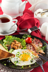 English breakfast with bacon, fried egg and beans