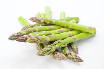 tips raw green asparagus on white