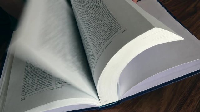 book, close-up of a great book, a book pages quickly turned over and thumbed through, man looking in the book of the desired page