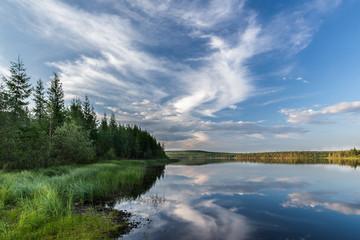 Summer evening landscape with lake, cloudy sky and forest. Yakutia. Russia.