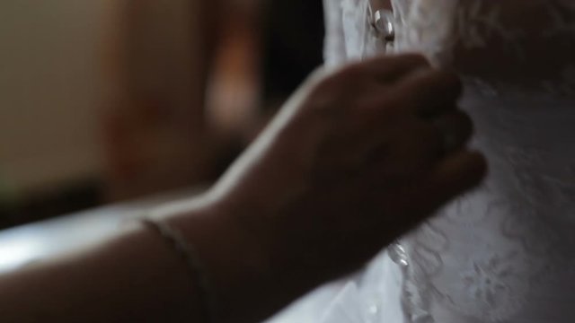 Buttoning the wedding dress