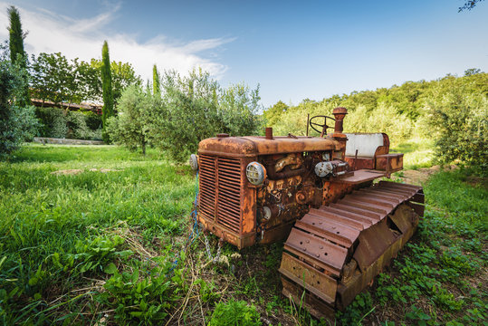 Old rusty tractor neglected under the tree
