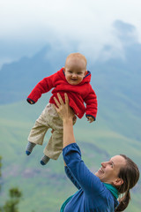 Fototapeta premium Mutter wirft Baby in die Luft