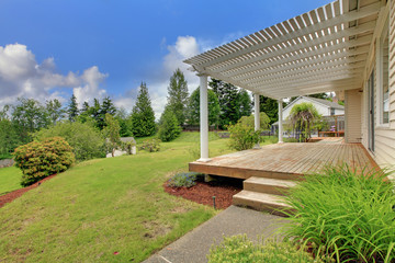 Wooden front deck of home with green lawn