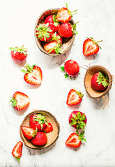 Fresh juicy strawberries in coconut shell, top view
