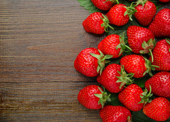 Many fresh strawberries on old wooden background