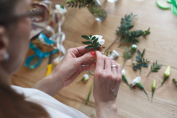Florist at work: woman making floral composition of different flowers