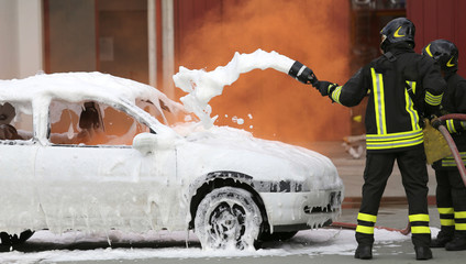 firefighters during exercise to extinguish a fire in a car
