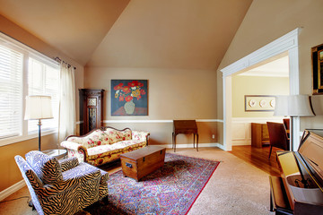 Cozy living room in light brown tones with high vaulted ceiling and piano.