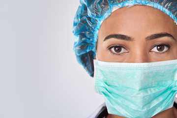 Mixed race female surgeon in surgical mask with copy space