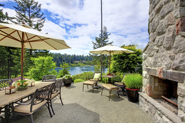 Obraz premium Patio area with concrete floor, patio table set and deck chairs.