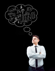 Businessman on a background of black wall.