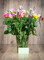 Beautiful flowers in the vase on wooden background