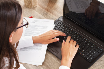 Mujer escribiendo en un ordenado portatil en un escritorio. Vista superior. Concepto: Trabajo - obrazy, fototapety, plakaty