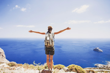 Back side of traveler young woman looking at the sea, travel and active lifestyle concept