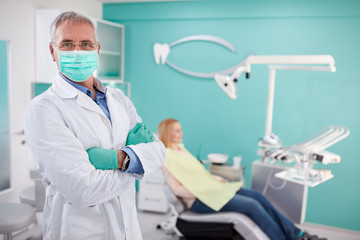 Dentist with protecting equipment posing in dental clinic