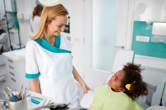 Cute girl talking with dental assistant in dental clinic