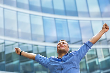 Man with arms raised outdoors
