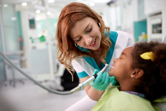 Black kid with female dentist in dental clinic