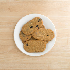 Blueberry wafer cookies on a white plate atop a wood table top view.