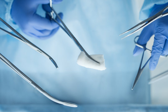 Close up view of doctor hands holding surgical tools